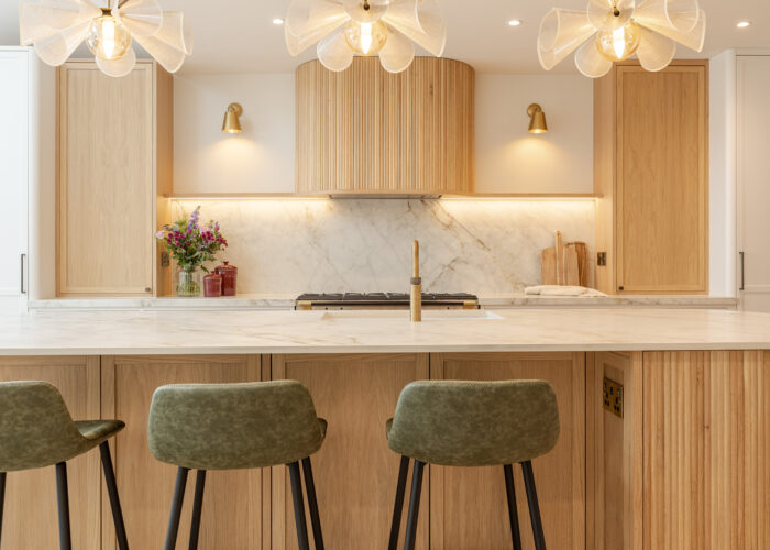 Custom made modern classical kitchen with large island, quartz worktop, and pendant lights and warm wood touch