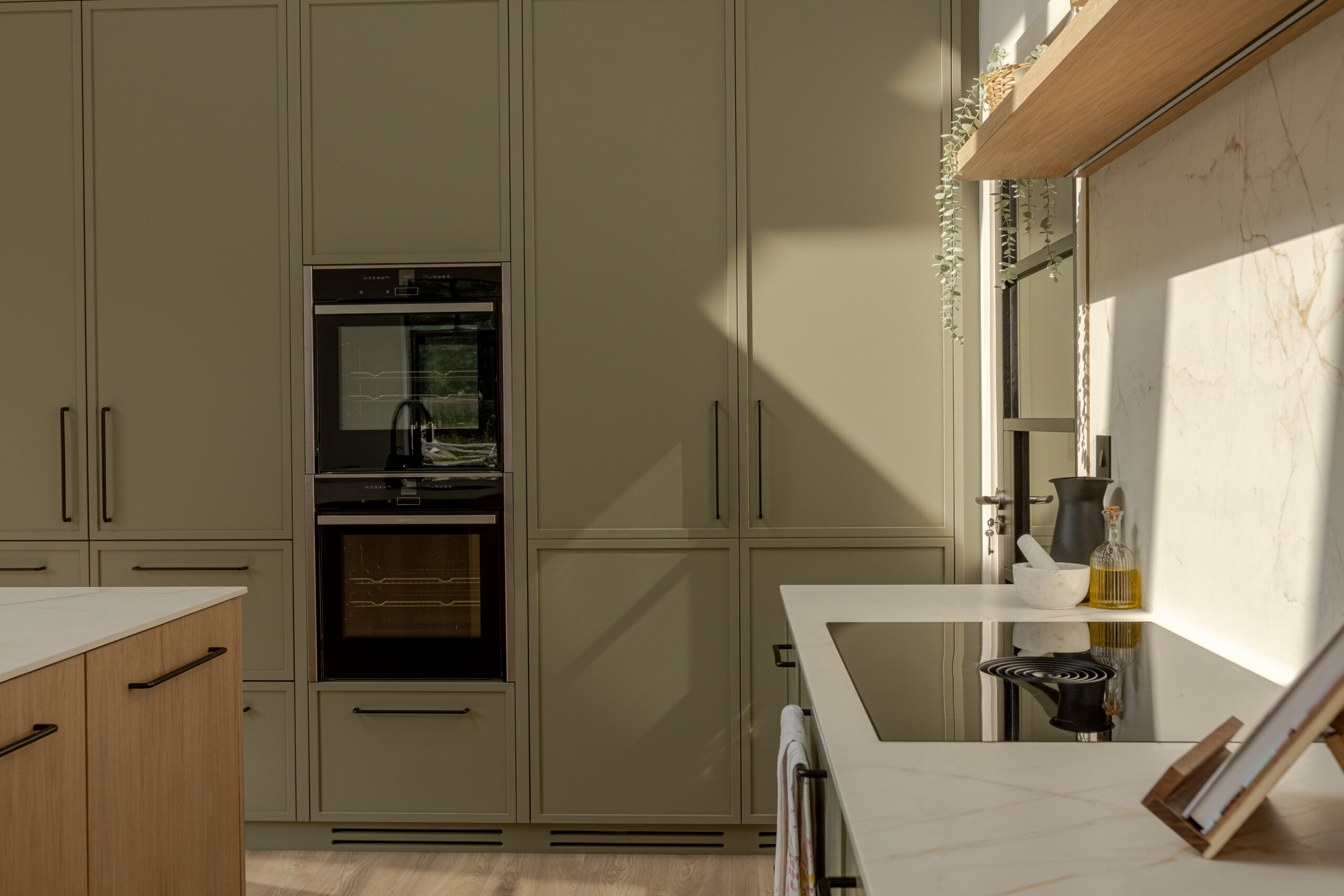 A refined modern classic kitchen combining timeless shaker cabinetry with contemporary finishes and natural warmth.